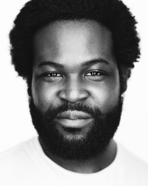 Black and white professional headshot of male with light background and clothing 